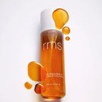 RMS Beauty Kakadu Body Oil, gold bottle with white cap and texture on white background, skin care