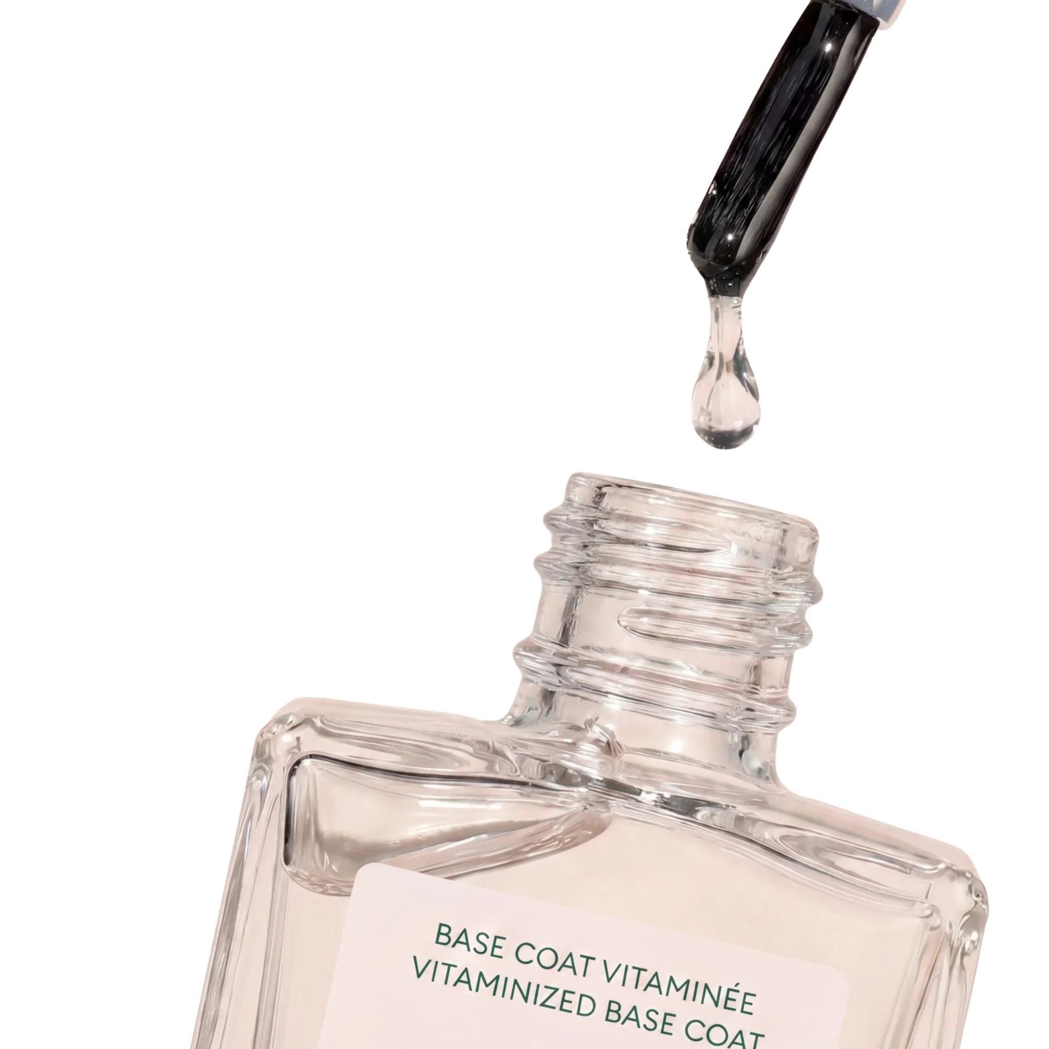 Vitaminized Base Coat in einer durchsichtigen Glasflasche mit Pinselapplikator auf weißem Hintergrund, Nagelpflege.