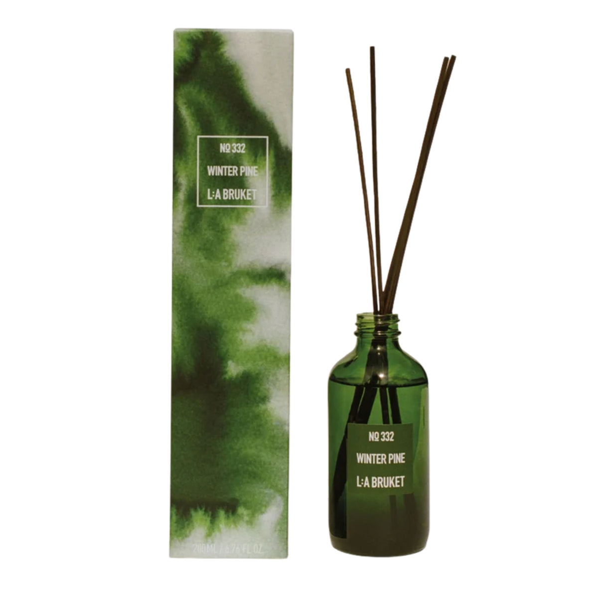 L:A Bruket No. 332 Winter Pine: Green glass bottle with diffuser sticks next to the matching cardboard packaging.